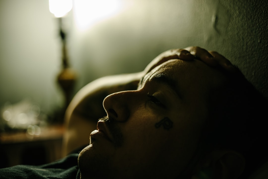 man feeling down childhood shame lying down in the dark