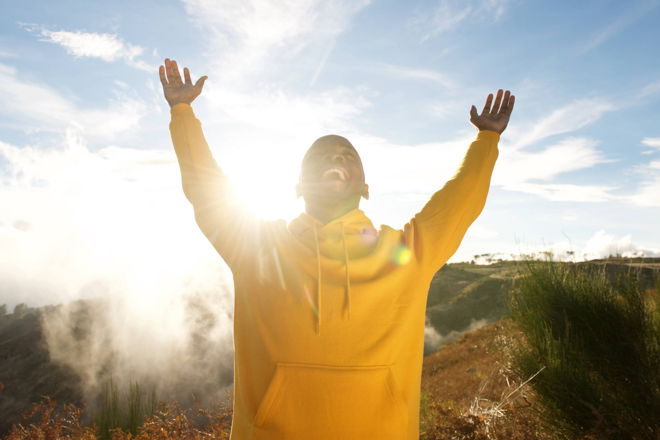 man with his arms up happy in sunlight showing 10 ways to love life