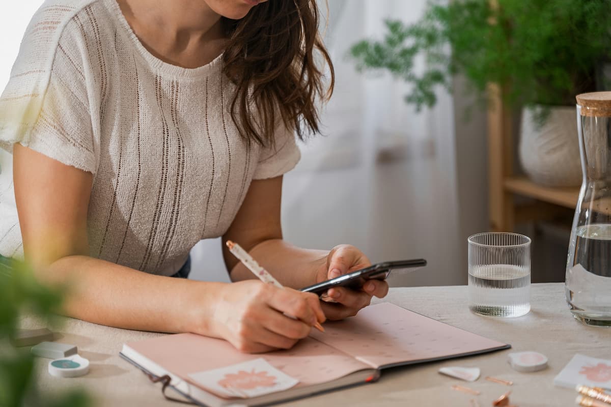 Woman writing out to do list making time for her dreams